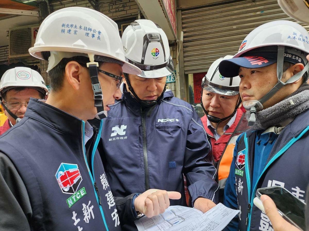 新北市副市長朱惕之(中)到場聽取工務局長馮兆麟(右2)及新北土木技師公會理事長賴建宏理事長(左2)說明肇事原因及處理方式。 圖：新北市工務局/提供