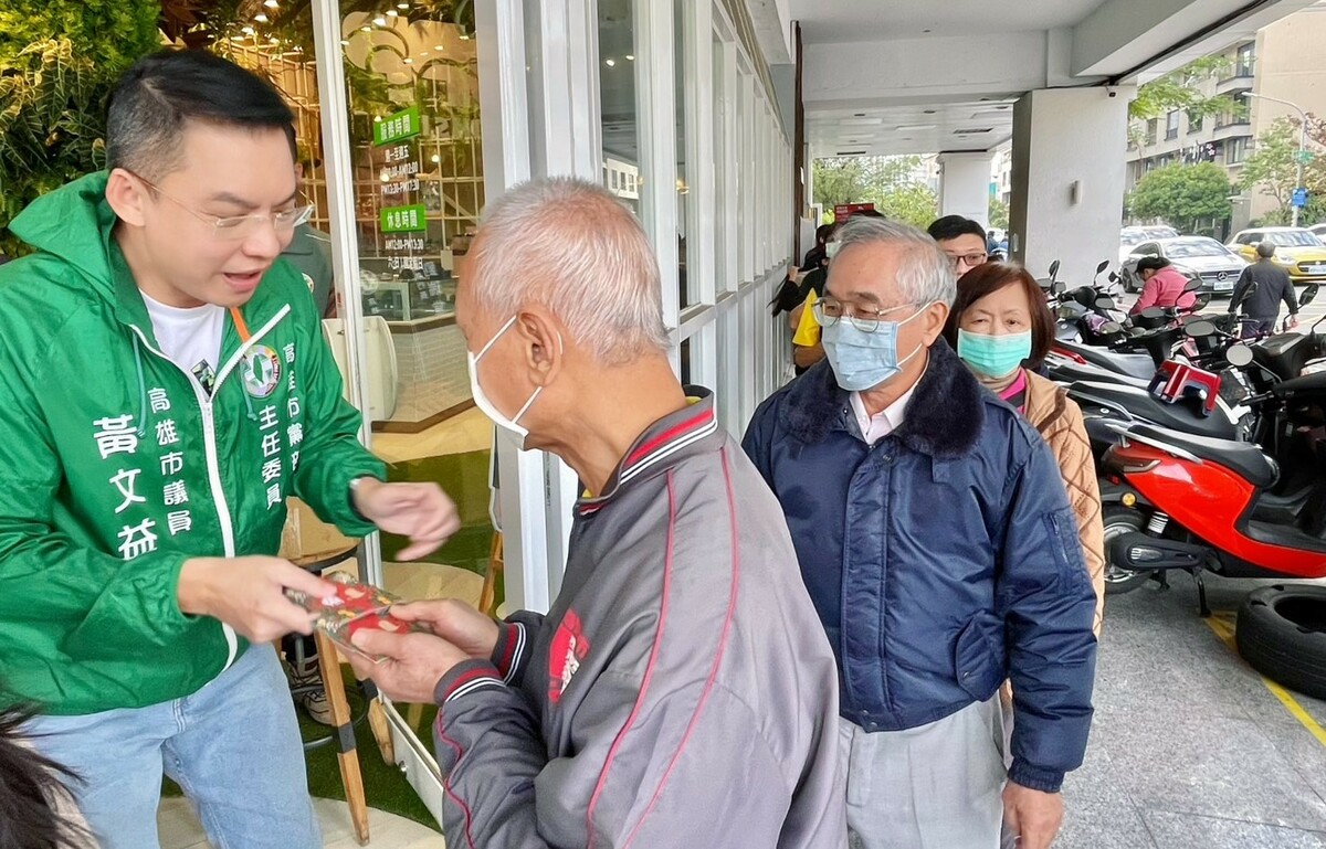 黃文益(左一)在黨部門口親自發送賴清德及陳其邁一元福袋。 圖：民進黨高雄市黨部提供