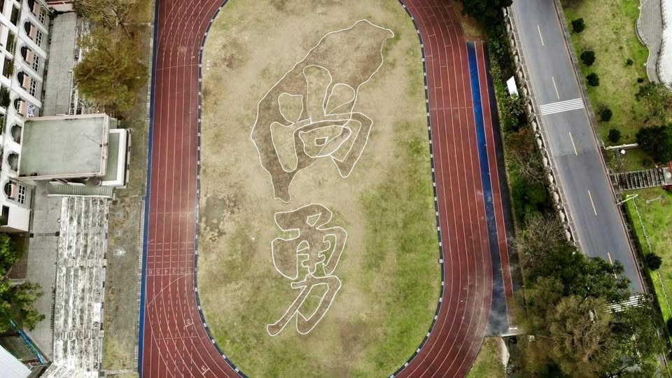 中華職棒大聯盟會長蔡其昌臉書附圖PO文，指新北淡水新興國小工友阿伯在操場以除草機「繪製」出台灣圖案和「尚勇」兩字。 圖：翻攝「臉書」蔡其昌粉絲專頁