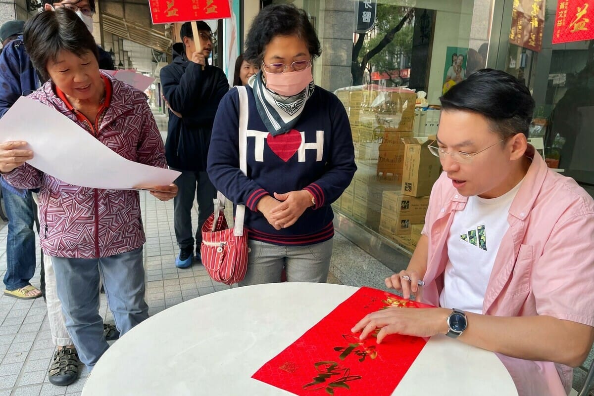 黃文益(右)在春聯上親筆簽名。 圖：民進黨高雄市黨部提供