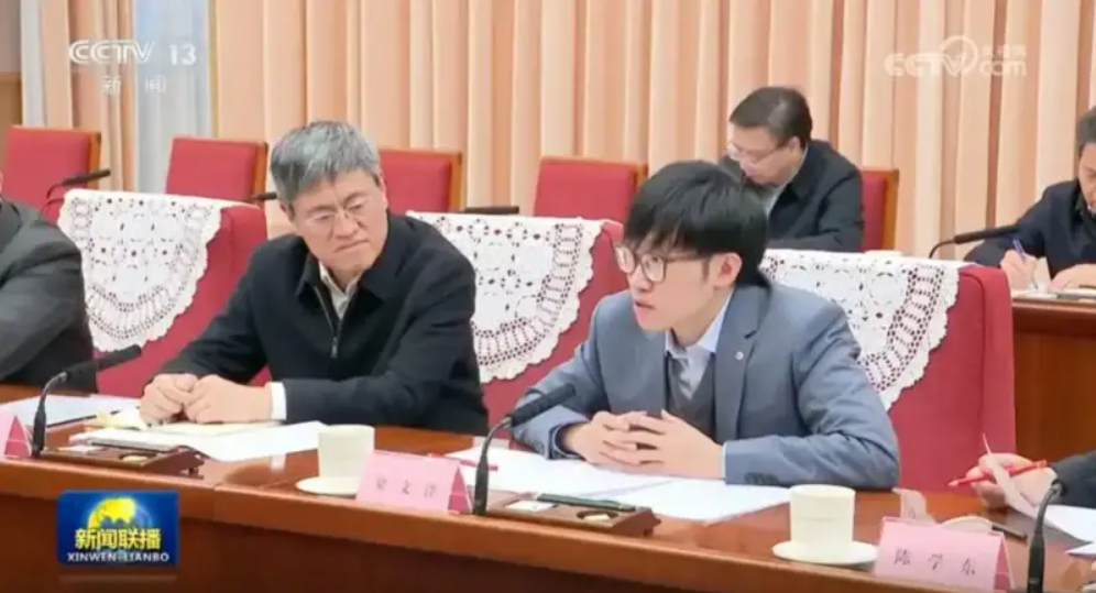 許多中國人把 DeepSeek 創辦人梁文鋒（灰色西裝者）視為天才。 圖：翻攝央視（資料照片）