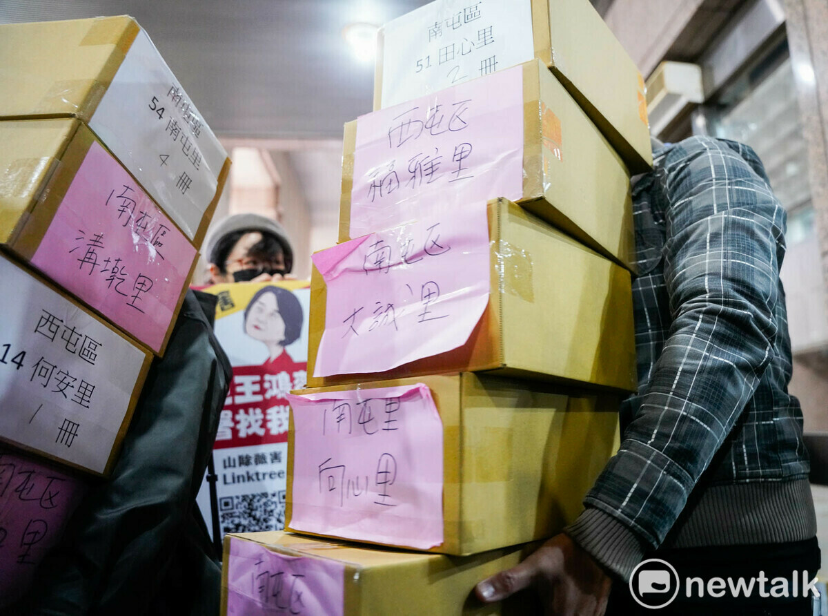 志工們抱著一箱箱裝著罷免國民黨立委廖偉翔的罷免提議連署書到中選會繳交。 圖：張良一/攝