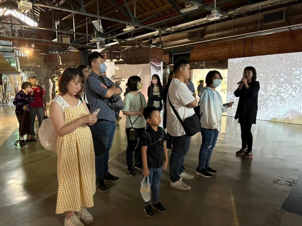 策展人黃雅玲(右一)於現場進行導覽。 圖：高科大創新設計學院提供