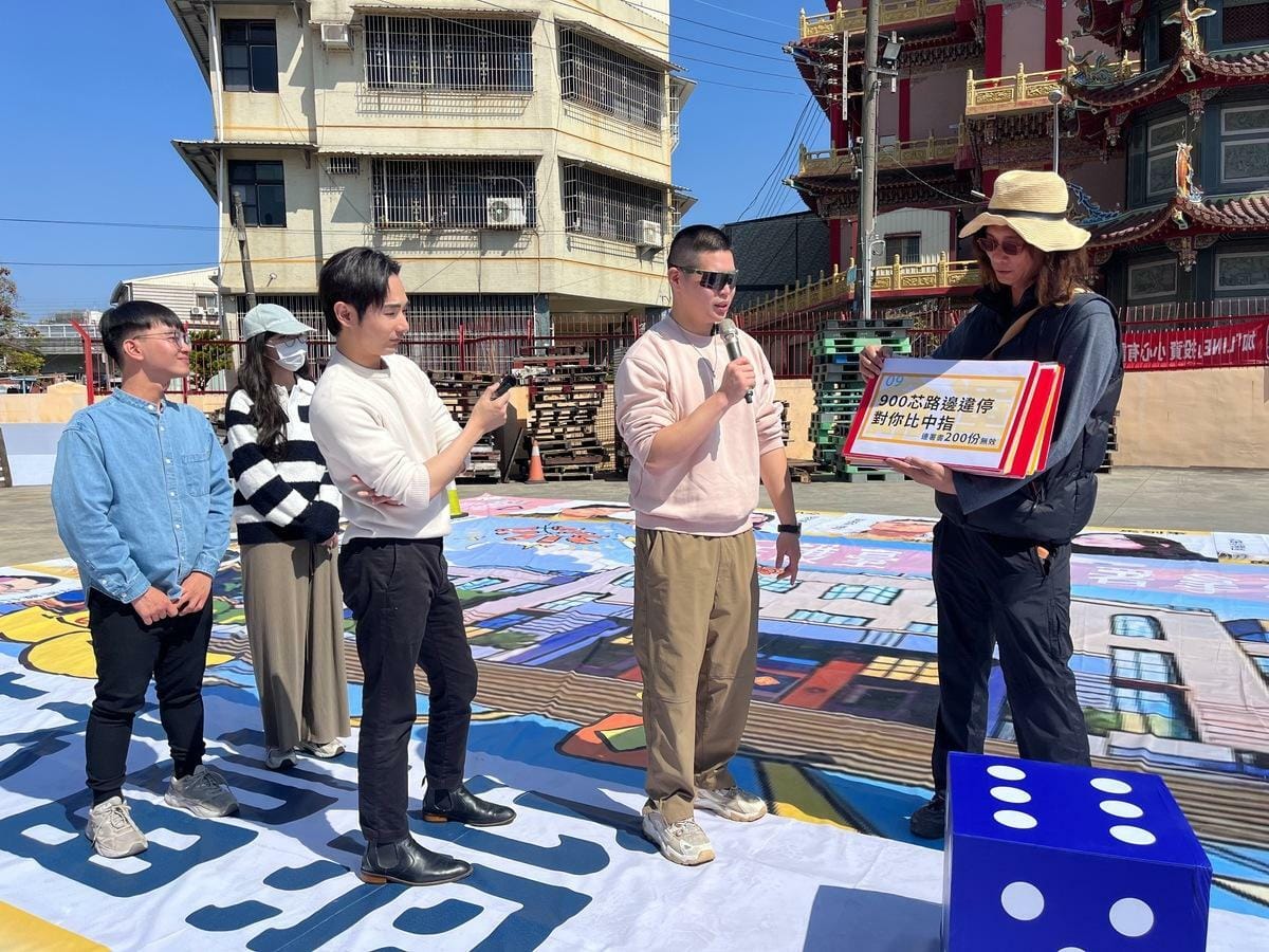 八炯(中)、閩南狼PYC(右二)共玩「真人版」「民主大富翁」遊戲。 圖：鍾佳濱服務處提供
