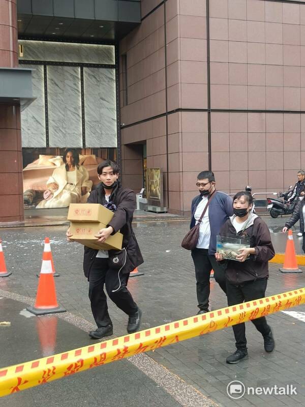 新光三越爆炸案發生後，不少員工抱著重要物品撤離。 圖：唐復年/攝