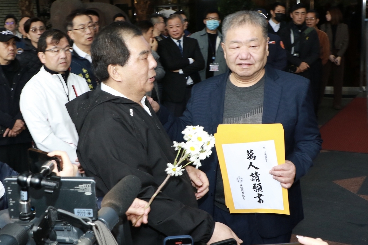 市議會周勝考將反對板殯改建的萬人請願書轉交給議長蔣根煌。 圖：林昀真/攝