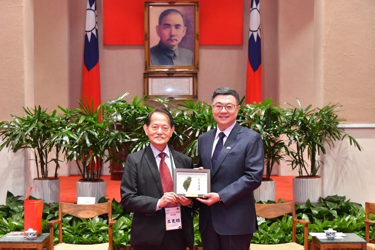 行政院長卓榮泰（右）24日在行政院接見海外228遺屬返鄉團，致贈紀念物給228事件受難者王育霖兒子王克雄（左）表達歡迎。 圖：行政院提供