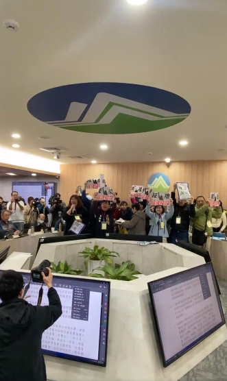 環團強調程序違法，並衝上主席台前，高喊「程序違法，立即散會」。 圖：翻攝自守護外木山行動小組臉書