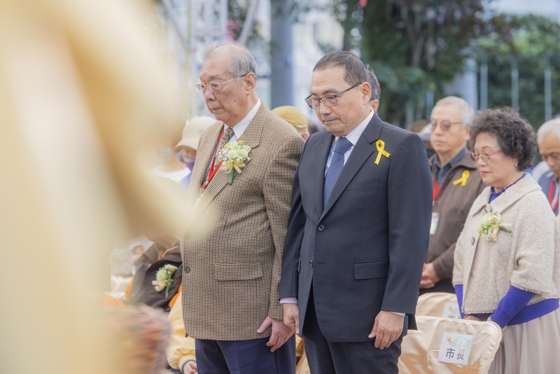 新北市228事件78週年紀念儀式，28日下午在三重區舉行，市長侯友宜（前右）率團隊，與新北市228總會理事長洪顯詔（前左）及受難者家屬一起默哀。 圖：新北市府新聞局提供