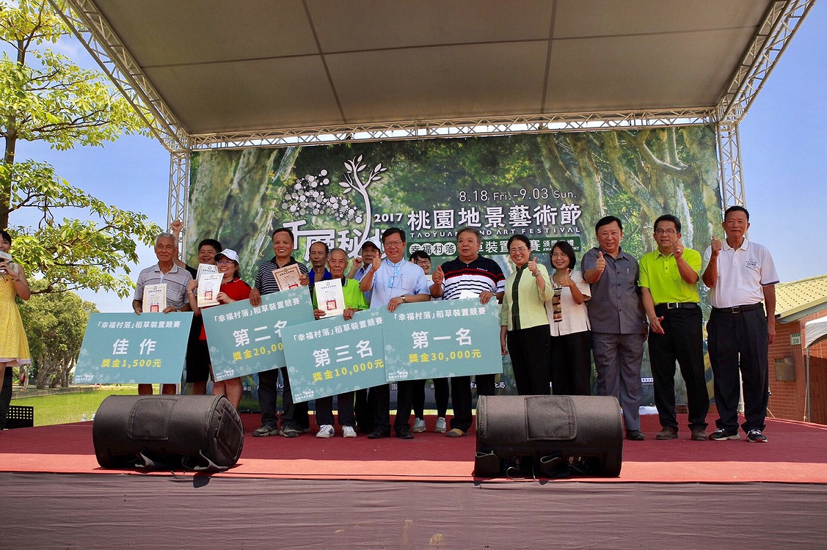 2017桃園地景藝術節舉辦了「幸福村落」稻草裝置競賽出爐，藉由「幸福村落」稻草裝置競賽，延續傳統稻草技藝，凝聚社區的向心力，落實桃園地景藝術節藝術打樁的在地參與的精神。今(19)日於觀音廣福主展區的假日藝術大道進行頒獎典禮，由市長鄭文燦頒發一至三名的得獎金。  圖：桃園市政府文化局提供