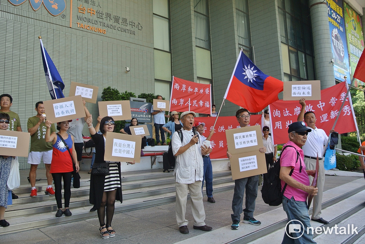 國民黨全國代表大會會場外，自家人舉牌抗議。 圖：唐復年/攝