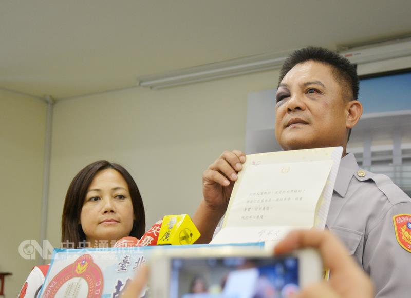 反年改民眾19日晚間在世大運開幕式時抗議，導致員警 劉金銓（右）受傷，劉金銓20日在太太（左）陪同下出 席記者會，並出示總統蔡英文的慰問狀。 圖 : 中央社