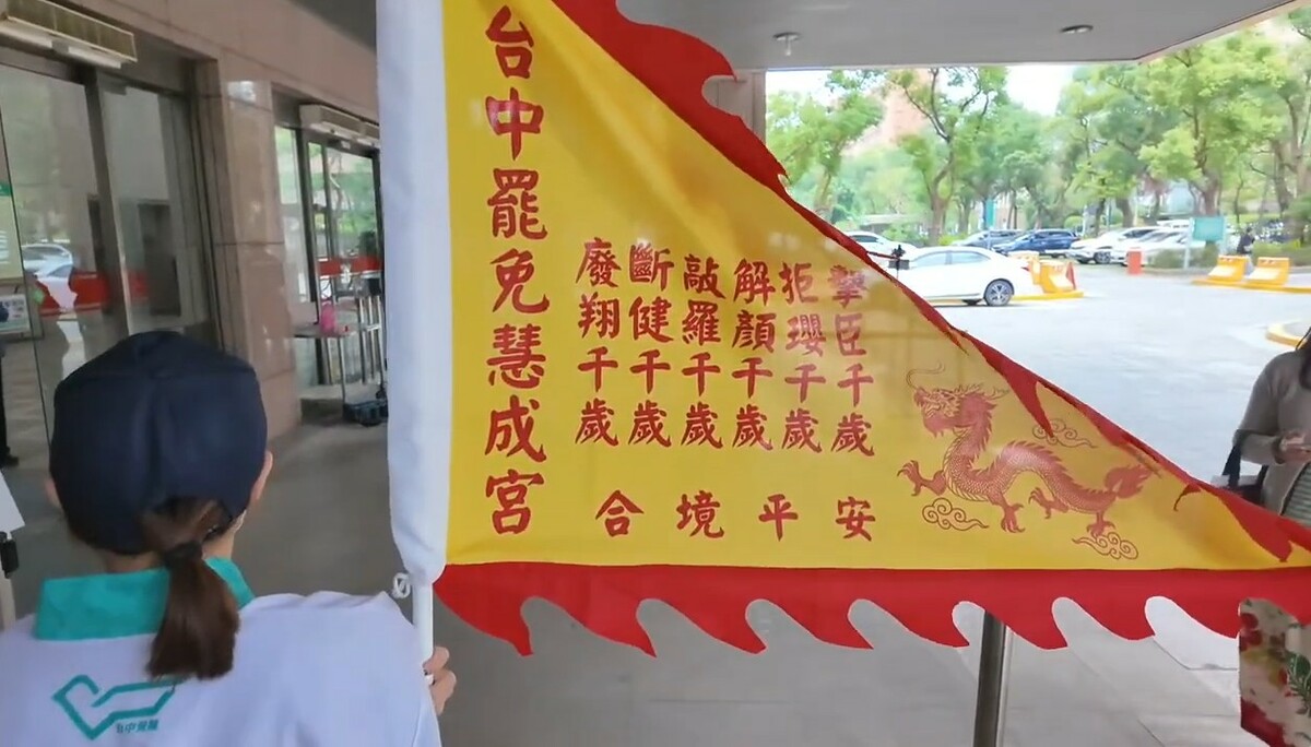 台中罷團舉著「罷免慧成宮」令旗到中選會領取罷免選區立委第二階段連署書。 圖：截自四叉貓YT