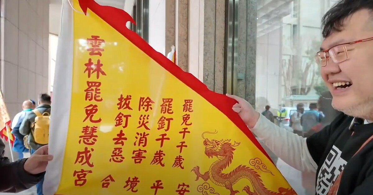 雲林罷團舉著「罷免慧成宮」令旗到中選會領取罷免選區立委第二階段連署書。 圖：截自四叉貓YT