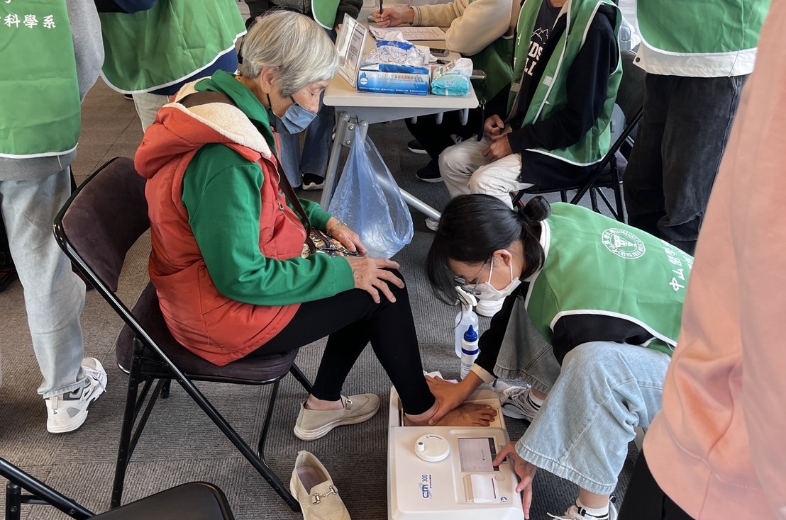醫影系學生為長輩量測骨質密度，防止骨鬆風險。 圖：中山醫大／提供