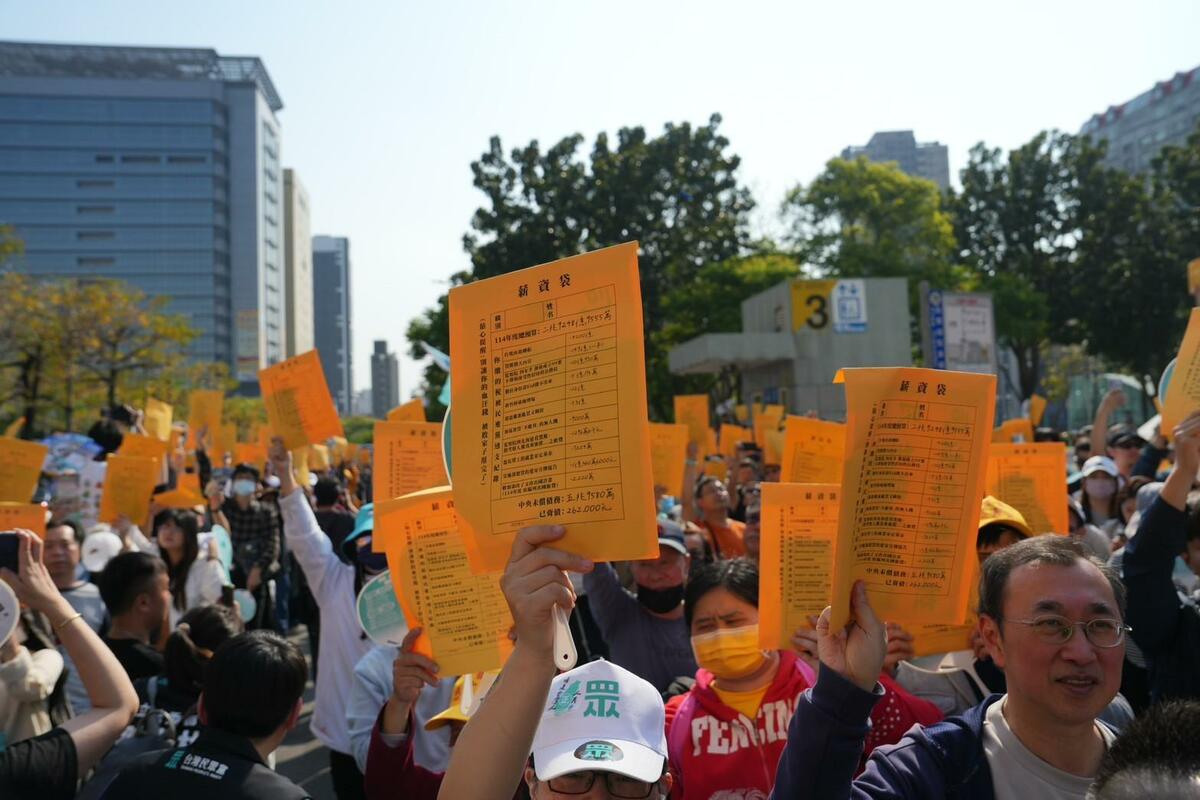 民眾黨支持者高舉「薪資袋」，控訴民進黨只會喊「抗中保台」，但實際上包庇綠色權貴。 圖：民眾黨提供