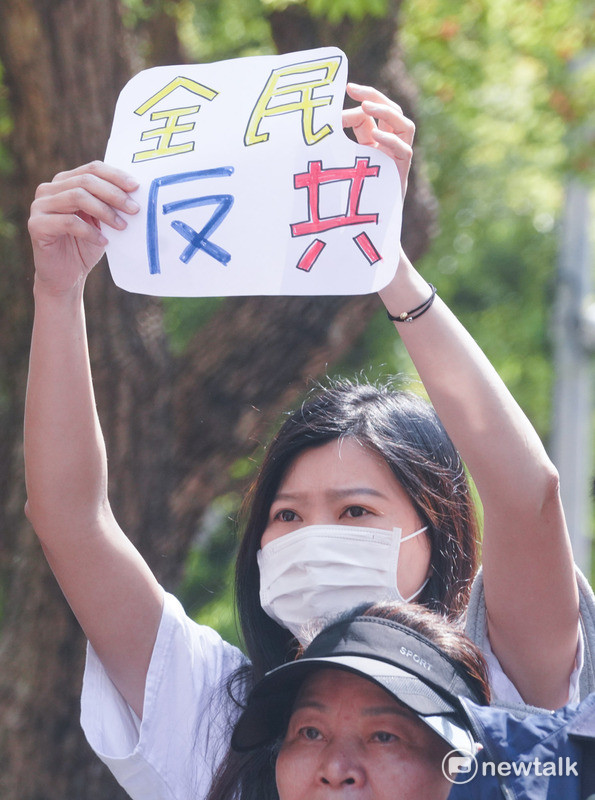 民眾手持全民反共標語赴記者會現場抗議。 圖：張良一/攝