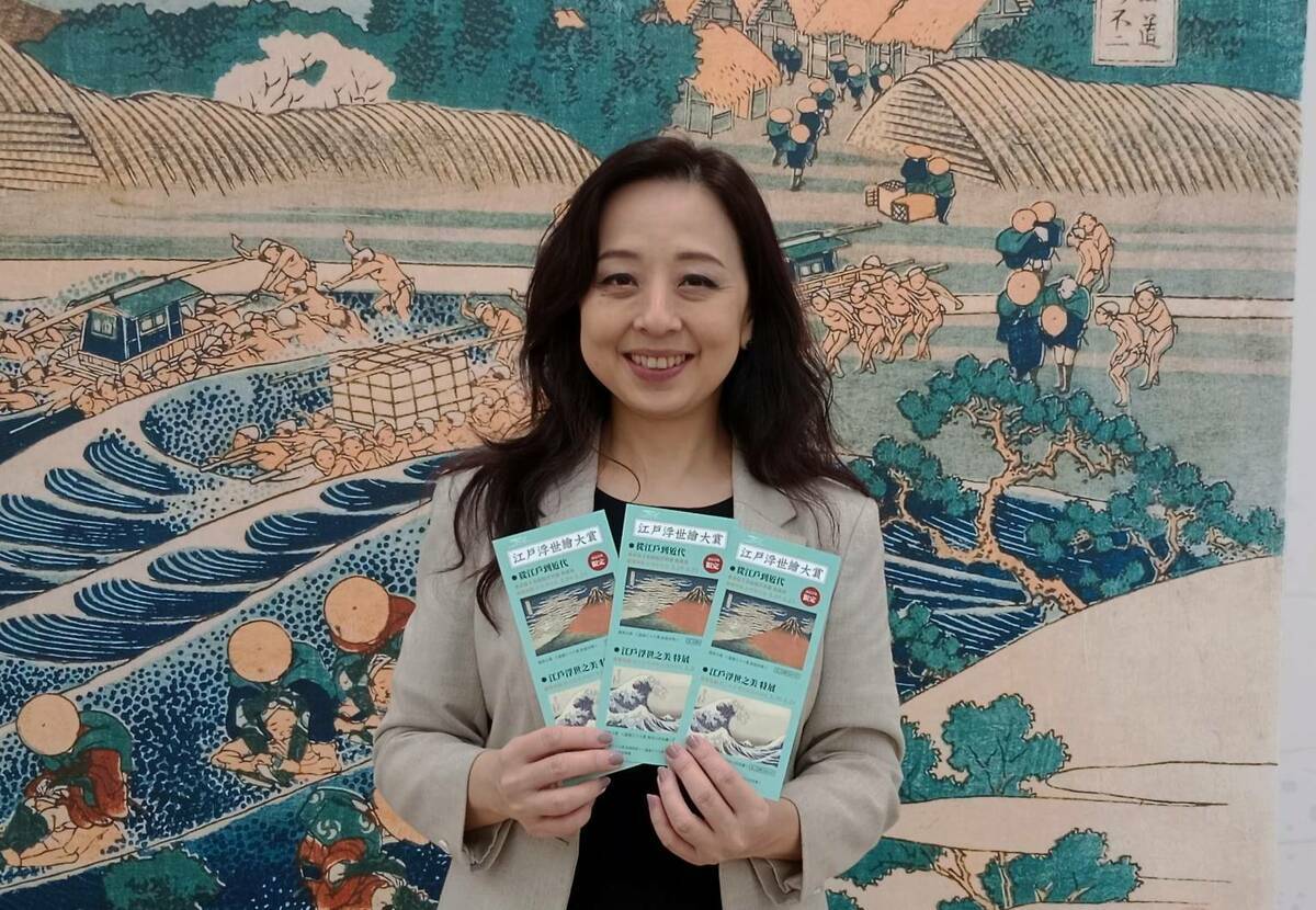 呂慧甄展示創美館與故宮南院的兩館聯名藏書票，憑此票券至故宮南院可享八折優惠。 圖：孫家銘攝