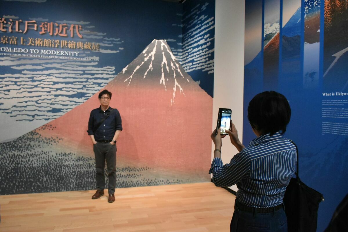 民眾在展場入口的富士山大幅浮士繪輸出大圖留影。 圖：孫家銘攝