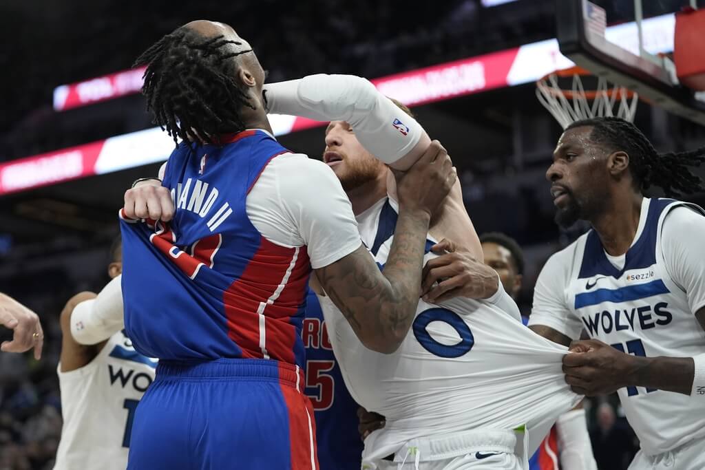美國職籃NBA明尼蘇達灰狼隊和底特律活塞隊30日交手，活塞霍蘭德（左）與灰狼後衛迪文森索（中）在第2節爆發嚴重衝突。（美聯社）