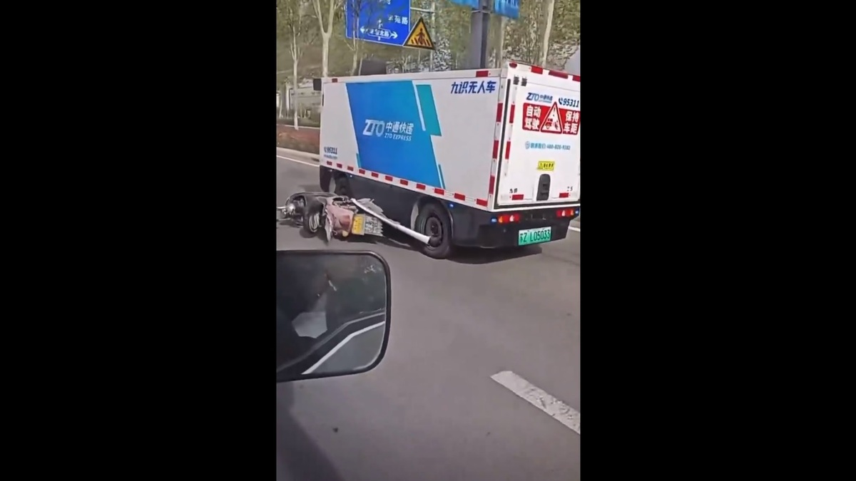 一輛中國的無人貨運車卡著一輛電動機車在路上跑，許多網友也對中國「智能駕駛」的安全性抱持著擔憂的情緒。 圖：擷取自 @muyang909 X 分享影片