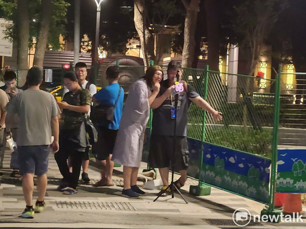 側翼四叉貓也在距離北檢不少處的馬路分隔島上直播，偶爾與零食藍營支持者互嗆。 圖：黃建豪/攝