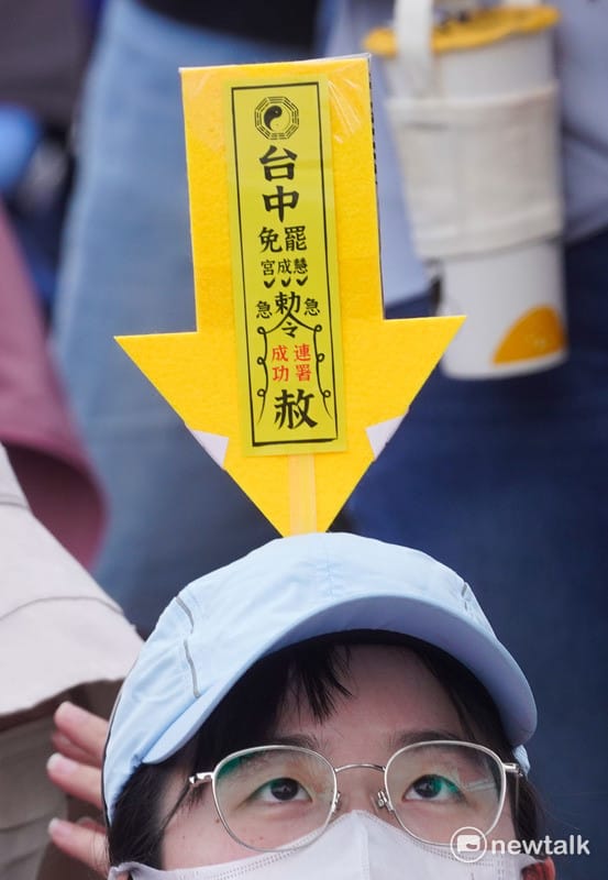 一位參加遊行的民眾將台中罷免慧成宮的符令插在自己的帽子上。 圖：張良一 /攝