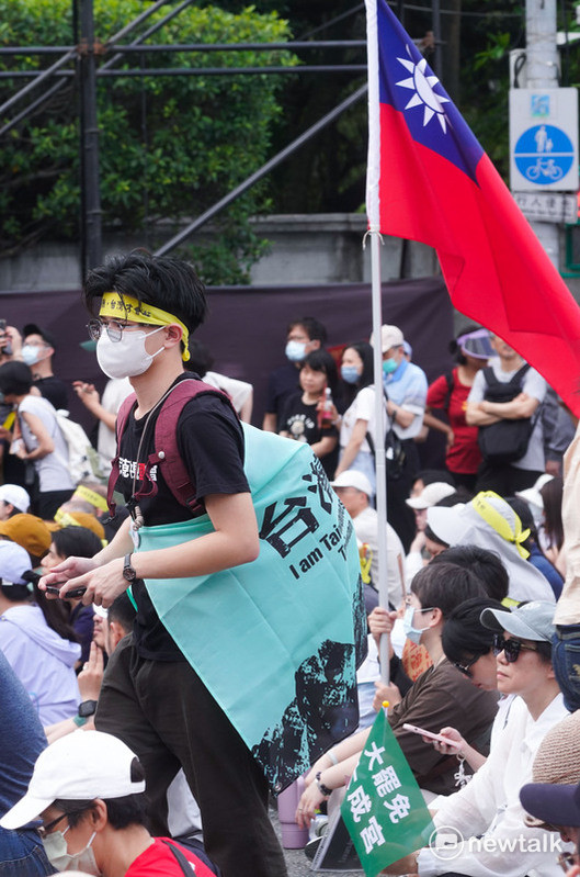約五萬民群眾參與在凱達格蘭大道舉行的『419守護台灣 拒絕統戰』大遊行，人潮從凱達格蘭大道滿溢到仁愛路與信義路口，場面相當熱烈，一位民眾揹著台灣獨立旗從中華民國國旗旁邊經過，中華民國國旗與台灣獨立旗、台灣魂大旗並列出現在活動現場，不少民眾也拿著小幅國旗在人群中。一場大罷免遊行，讓中華民國派與台派走在一起，這是過往台派活動少見的景象。 圖：張良一 /攝