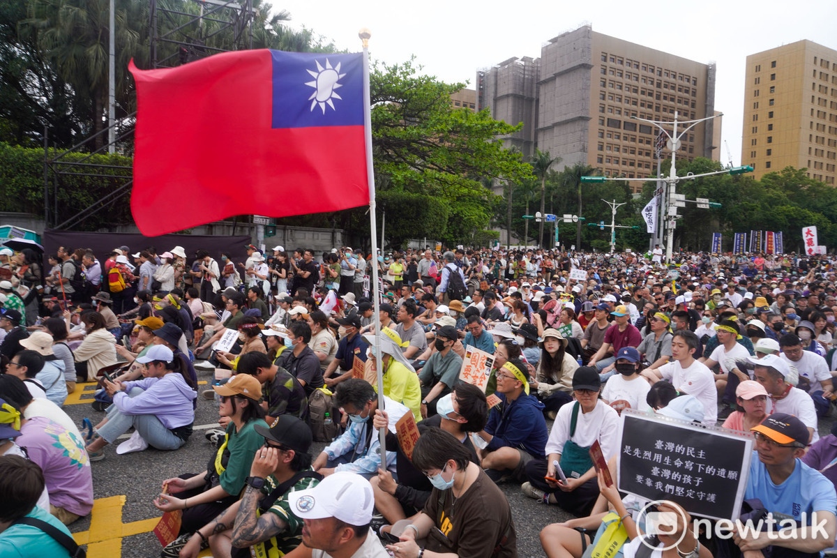 一面中華民國國旗在凱達格蘭大道的人群中飄揚。一場大罷免遊行，讓中華民國派與台派走在一起，這是過往台派活動少見的景象。 圖：張良一 /攝