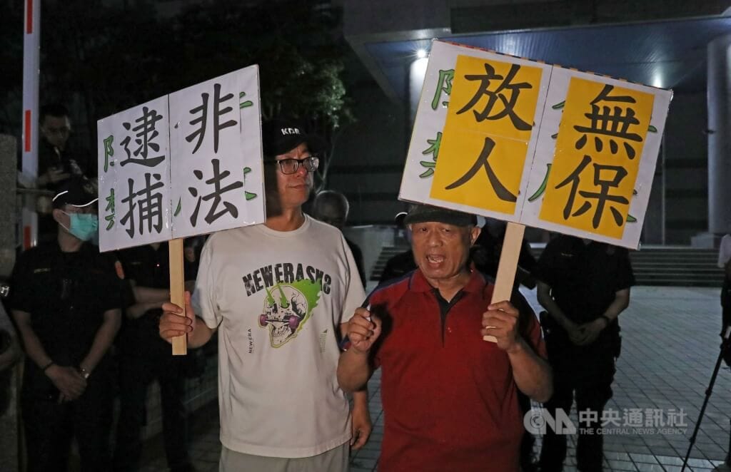 高雄「雙罷劫連署總站」負責人徐尚賢涉不實連署案遭聲押，徐尚賢父親（前右）與罷免案領銜人之一的朱磊（前左）等人19日晚間到高雄地檢署關心偵辦進度，高喊非法逮捕、無保放人等口號。中央社記者張已亷攝 114年4月19日