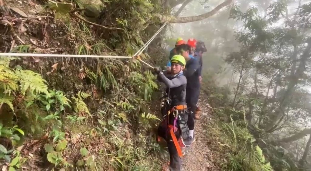 7人登山團19日前往屏東北大武山，有團員不慎摔落60米深山坡，警消人員獲報趕抵，架設繩索下降救援。 圖：中央社（屏東縣消防局提供）