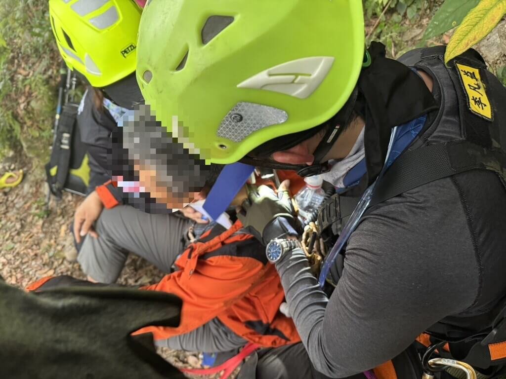 屏東縣消防局19日獲報北大武山登山步道1.75K處，有男性登山客不慎跌落山坡，警消架設繩索下降馳援，將男子拖拉至步道，意識清楚但身體多處擦傷，送醫救治。 圖：中央社（屏東縣消防局提供）
