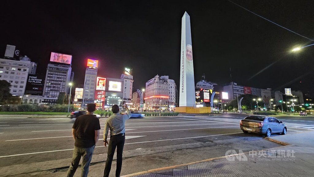 阿根廷首都布宜諾斯艾利斯地標方尖碑（Obelisco）今年2月投影出教宗方濟各的影像，民眾停留拍攝，並為當時病危的教宗祈福。如今教宗辭世，這畫面也成為民眾追思的回憶之一。 圖：中央社提供