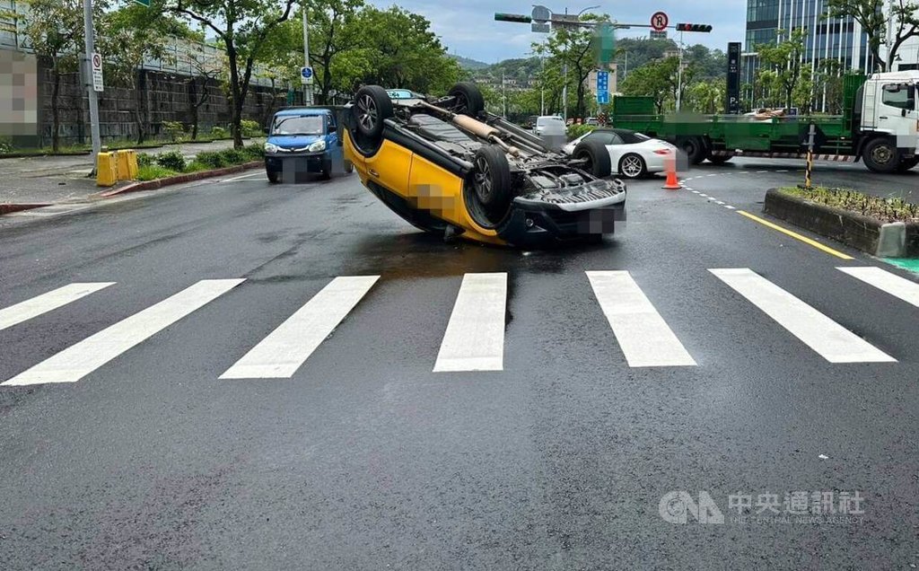 台北市南港區23日發生計程車翻車事故，66歲鄭姓男子載客行經經貿二路要左轉時，不慎碰撞中央分隔島而翻車，場面驚險，所幸無人受傷。（翻攝照片）中央社記者黃麗芸傳真  114年4月23日