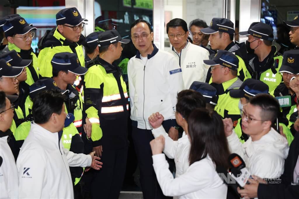 國民黨主席朱立倫（白衣中）晚間走出警局時，多名立委在外聲援打氣。中央社記者張新偉攝 114年4月26日