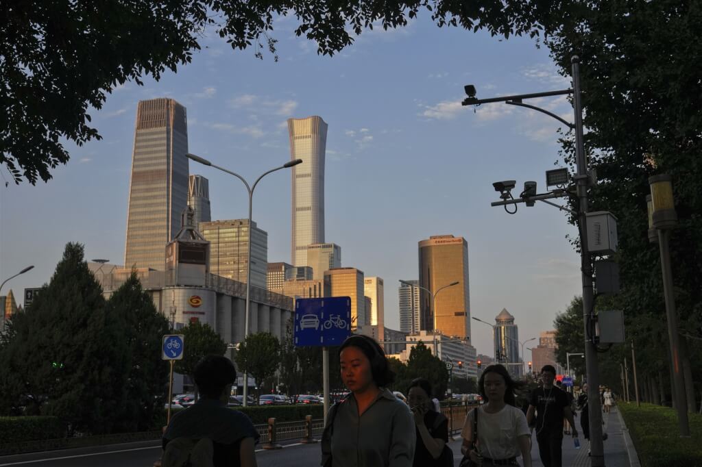 圖為中國民眾走在北京商務區街道。（美聯社）