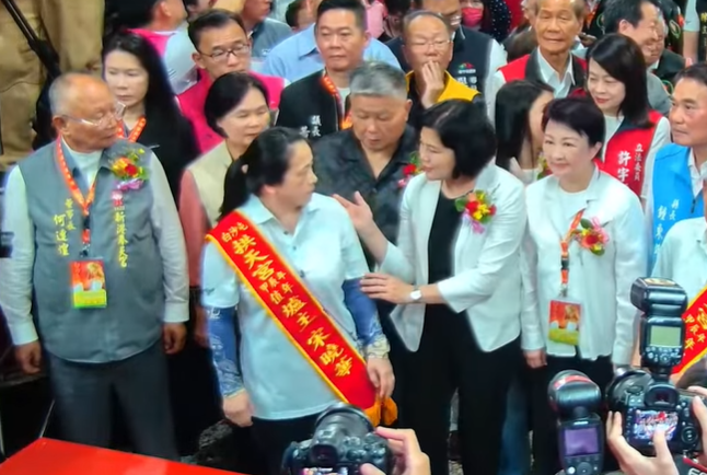 張麗善為了不讓自己與台中市長盧秀燕被擋住，竟伸手將前方爐主移開，引來網友痛斥。 圖：翻攝自白沙屯媽祖網路電視台