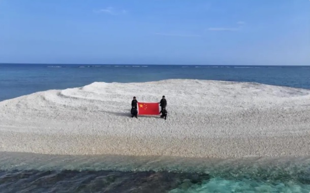 中國海警也派遣人員前往鐵線礁高舉五星紅旗宣示主權。 圖：翻攝自 騰訊網 地球編輯