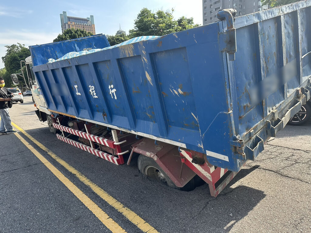 台中市西區英才路與公益路口附近路面2日下午驚傳塌陷，一輛路過貨車後輪陷入坑洞無法動彈，車身明顯傾斜。（民眾提供）中央社記者郝雪卿傳真  114年5月2日