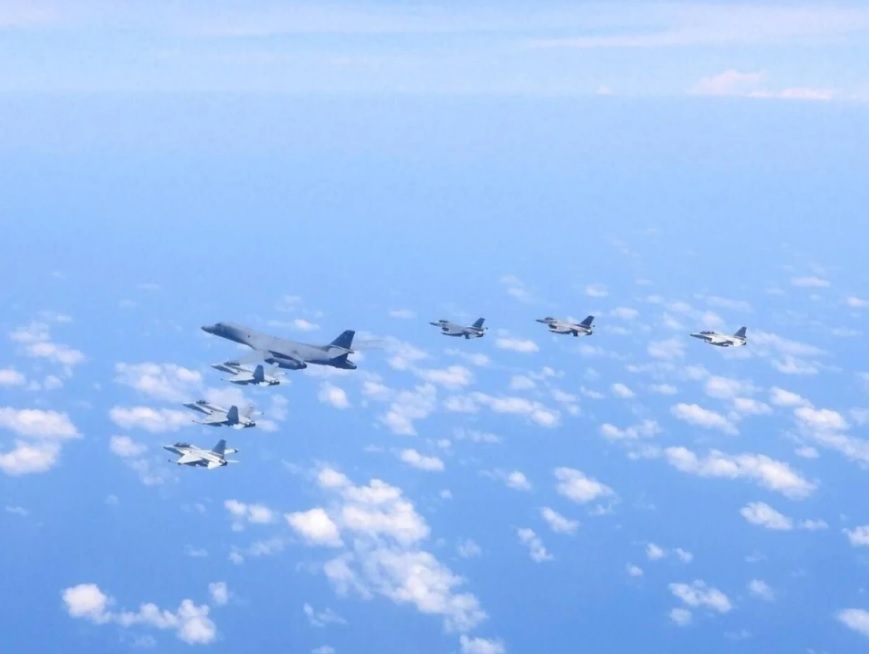 美軍B1-B轟炸機與6軍機在南海上空飛向黃岩島。 圖：翻攝自 騰訊網 鼎盛軍事
