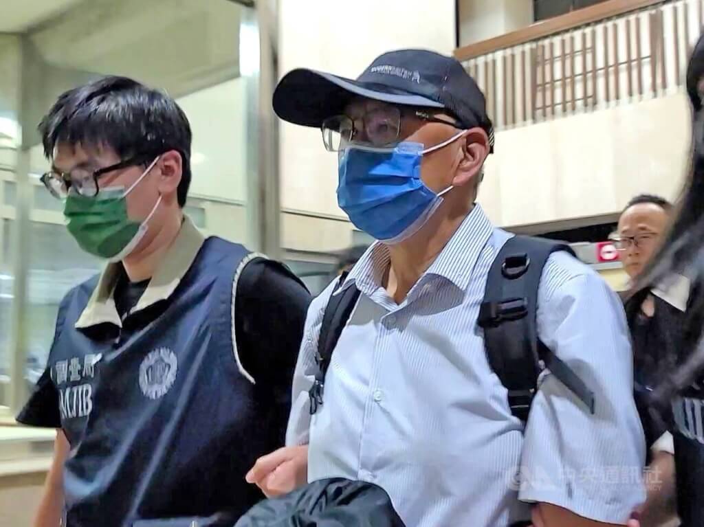台北地檢署偵辦國民黨立委傅崐萁涉競選小物案，遭通緝的被告李慶隆（前右）9日主動投案，法務部調查局北部地區機動工作站晚間將李慶隆上銬解送北檢歸案，李慶隆全程不發一語。中央社記者謝幸恩攝  114年5月9日