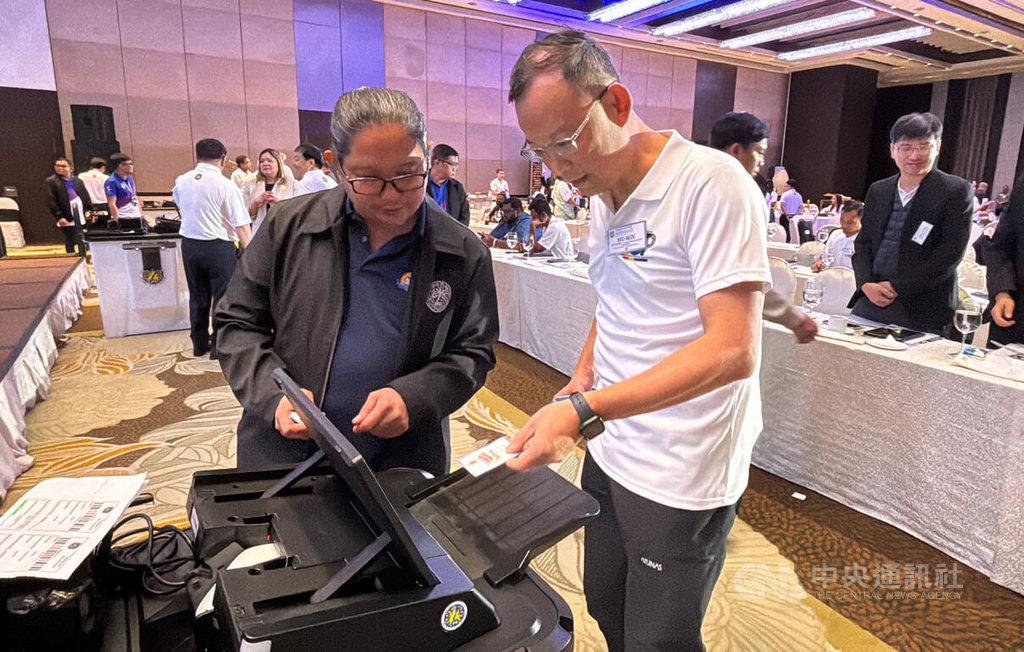 菲律賓將於12日舉行期中選舉，台灣民主基金會副執行長陳牧民前來馬尼拉觀選。圖為陳牧民（前右）在菲律賓選委會簡報會上試用菲國投票機。中央社記者林行健馬尼拉攝  114年5月11日