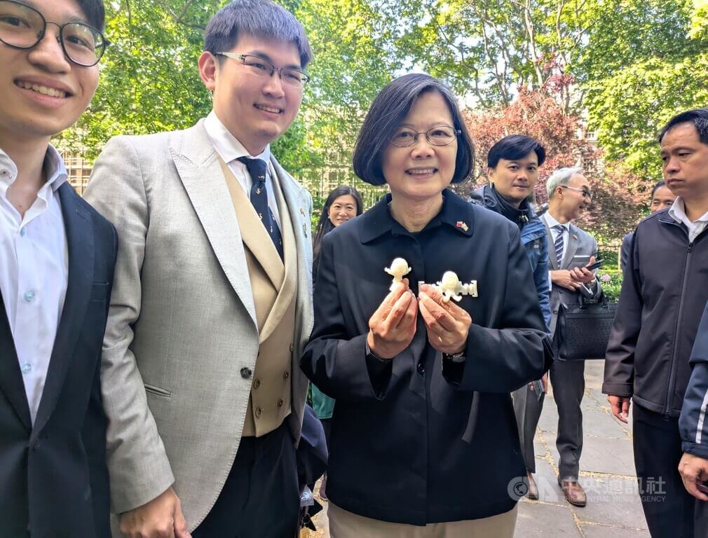前總統蔡英文（右）於英國時間17日在倫敦街頭漫步，公費留學生陳加恩（中）趨前致贈附有「小英公仔」的特製口罩減壓帶。減壓帶是台灣設計，在倫敦的醫學實驗室以3D列印技術產出。 圖：中央社提供