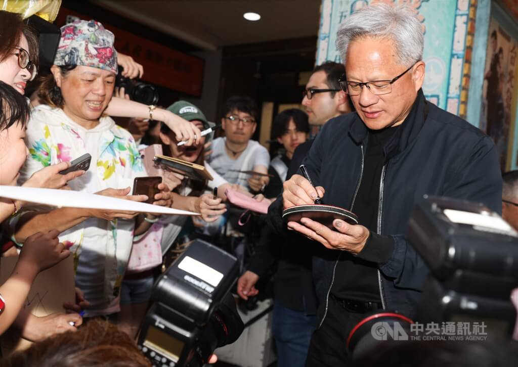 輝達執行長黃仁勳（右）17日傍晚在台北宴請供應鏈夥伴，吸引大批媒體、粉絲在店外守候，黃仁勳席間數度走出餐廳親切為粉絲簽名。 圖：中央社檔案照片