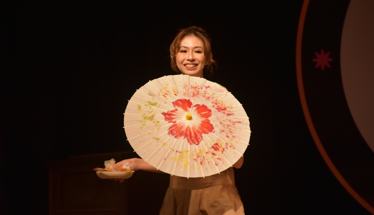 佳麗現場即興創作客家油傘畫。 圖：孫家銘攝