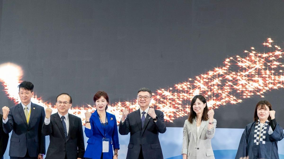 行政院長卓榮泰等人在舞臺上舉手握拳，為台北國際觀光博覽會開幕高喊「加油！加油！加油！」，共同完成開幕儀式並合影留念。 圖：行政院提供