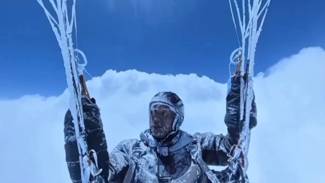 一名中國滑翔傘愛好者在祁連山區域飛行時，疑似遭遇空種亂流，意外被雲「吸至」八千多米高空，全身結冰。 圖 : 翻攝自央視新聞