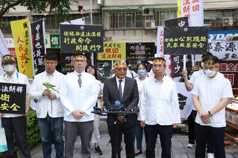 藥師公會帶來一隻「同胞鸚鵡」，象徵部長面對質疑時僅重複空泛說詞，缺乏實質回應。 圖：藥師公會／ 提供