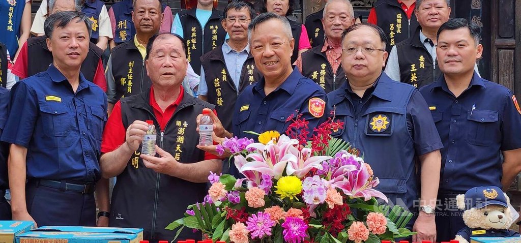 澎湖天后宮「保庇防詐水」贈水儀式，28日在天后宮前往廣場舉行，主委蔡光明（前左2）捐贈印有「保庇防詐水」字樣瓶裝水，澎湖縣警察局長林温柔率（前中）所轄3個分局長等代表接受，並回贈感謝狀給天后宮，現場也正好大批遊客前往參觀，分享防詐水保佑。中央社 114年5月28日