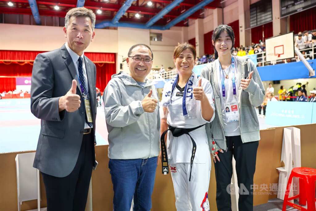 2025年雙北世界壯年運動會跆拳道個人對打賽事29日在新北市板樹體育館登場，跆拳道國手羅嘉翎（右1）的母親何千金（右2）以選手身分參賽，羅嘉翎父親羅文祥（左1）及新北市長侯友宜（左2）都到場觀賽加油。中央社記者王騰毅攝  114年5月29日